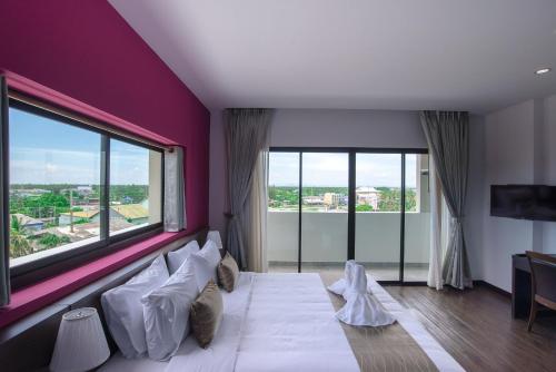 a room with a large bed with a large window at Coco View Hotel in Samut Songkhram