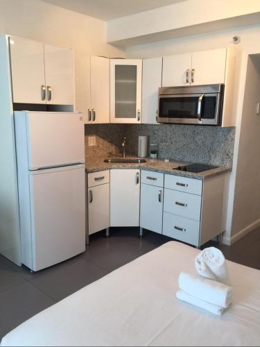 a kitchen with white cabinets and a white refrigerator at Ocean Front Units at Miami Beach in Miami Beach