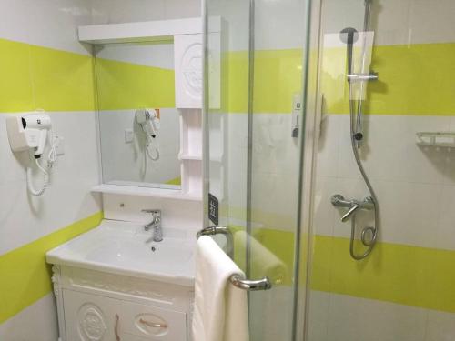 a bathroom with a sink and a glass shower at 7Days Inn Danyang Train Station Wuyue Square Branch in Zhenjiang