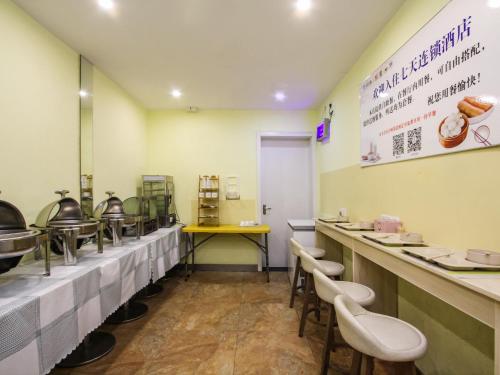 a fast food restaurant with tables and chairs at 7Days Inn Danyang Train Station Wuyue Square Branch in Zhenjiang