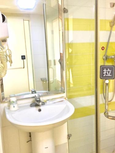 a bathroom with a sink and a mirror at 7Days Inn Chengdu Wuda Garden in Chengdu