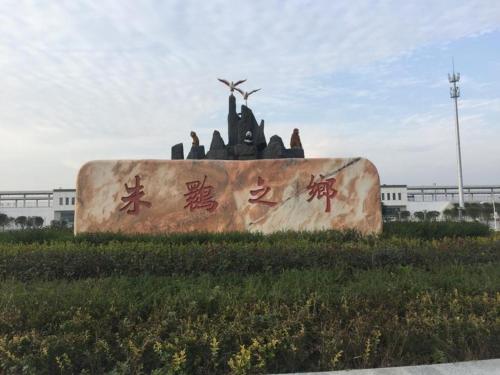 un gran monumento con escritura en él delante de un edificio en 7Days Inn Hanzhong Yang County Heping Road Branch, en Hanzhong