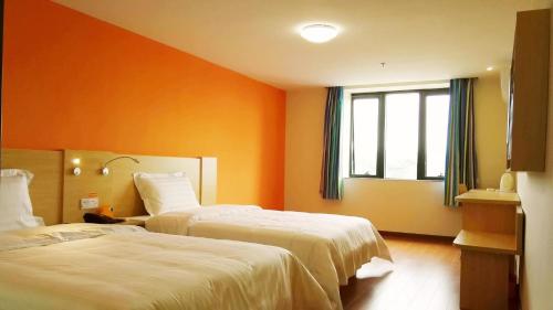 Habitación de hotel con 2 camas y ventana en 7Days Inn Enshi Railway Station Branch, en Longfengba