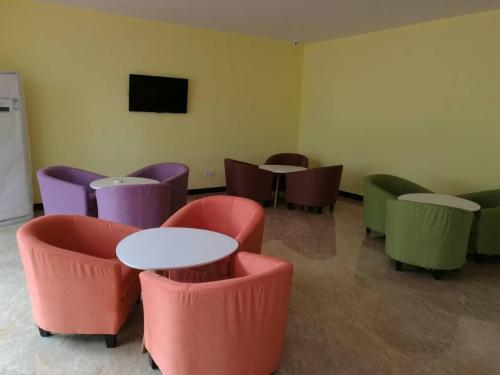 a waiting room with tables and chairs and a tv at 7 Days Inn Wuzhishan Yanhe South Road Branch in T'ung-shih-shih