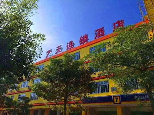 ein gelbes Gebäude mit roten Stühlen darüber in der Unterkunft 7 Days Inn Wuzhishan Yanhe South Road Branch in T'ung-shih-shih