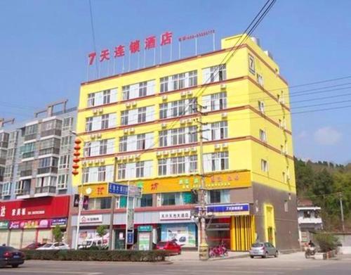 ein gelbes Gebäude an der Ecke einer Straße in der Unterkunft 7Days Inn Ziyang Lezhi Yingbin Avenue Branch in Ziyang