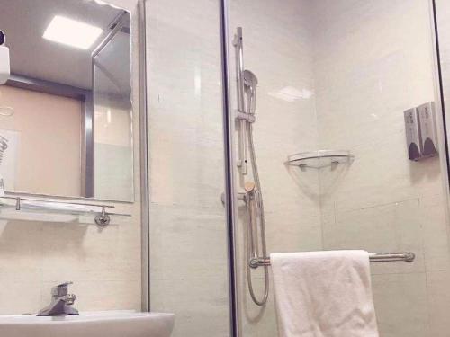 7 Days Inn Tianjin Jiaotong University Caozhuang Subway Station Branch في تيانجين: حمام مع دش ومغسلة