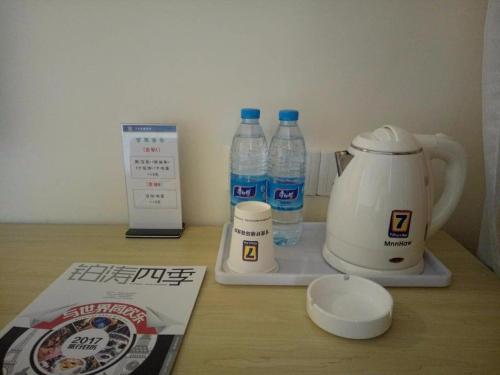 7Days Inn Tianjin Binhai Bus Station North China Ceramic Shop Branch في Binhai: كونتر بزجاجات ماء وخلاط