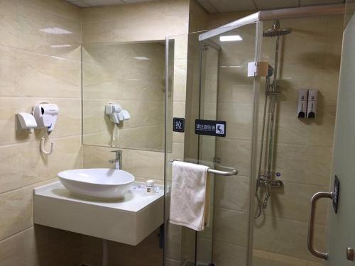 a bathroom with a sink and a glass shower at 7Days Inn Yancheng Yingbin Avenue Engineering College Branch in Yancheng