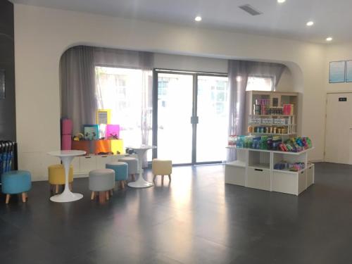 una stanza con sedie e tavoli e una libreria di 7Days Inn Santai Zizhou Avenue Branch a Mianyang