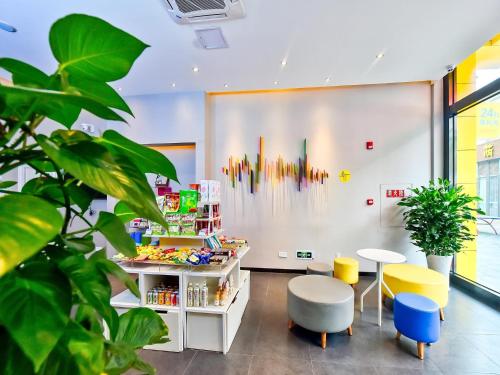 a waiting room with tables and chairs and plants at 7Days Inn Chengdu Mianzhu Branch in Deyang