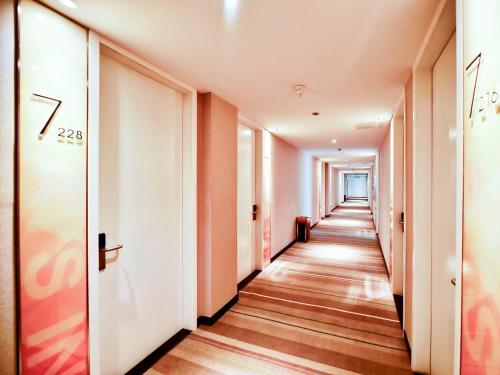 a corridor of corridors in an office building with wood floors at 7Days Inn Chengdu Mianzhu Branch in Deyang
