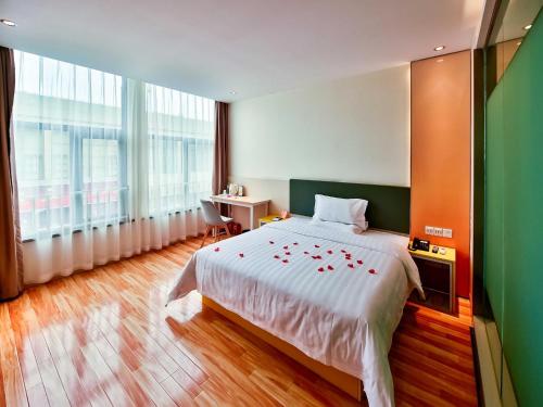 a bedroom with a large bed and a large window at 7Days Inn Chengdu Mianzhu Branch in Deyang