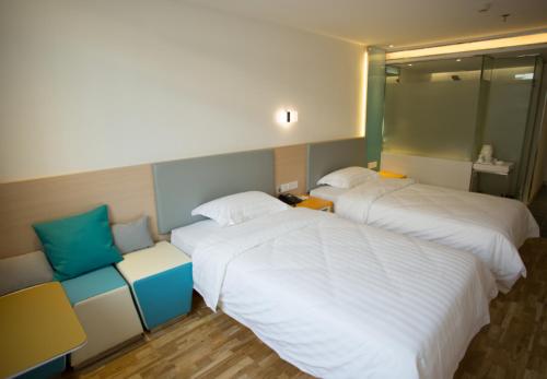 7Days Inn Quanzhou Dehua Cidu Avenue Branch tesisinde bir odada yatak veya yataklar