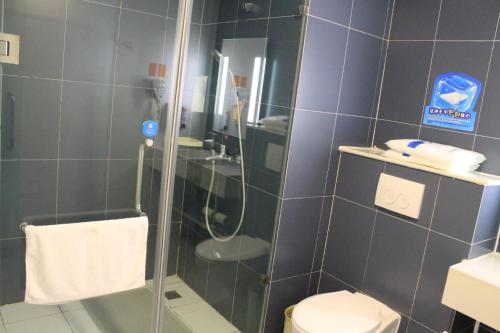 a bathroom with a shower with a toilet and a sink at 7 Days Hotel Ziyang Songtao Road Branch in Ziyang