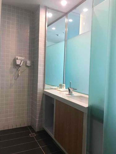 a bathroom with a sink and a mirror at 7Days Inn Urumqi Midong Middle Road Shenhua Mining Bureau Branch in Ürümqi