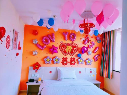 a bedroom with a bed with balloons and a heart on the wall at 7Days Inn Changzhi Qinxian Branch in Qinxian