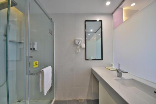 a bathroom with a shower and a sink and a mirror at 7Days Inn Dali Erhai Park Branch in Dali