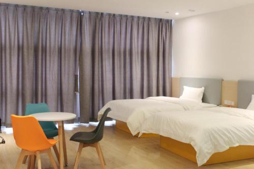 a bedroom with a bed and a table and chairs at 7Days Inn Chongqing Longtou Temple North Train Station North Plaza Branch in Chongqing