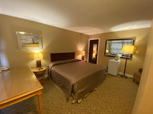 Habitación de hotel con cama y mesa en Twin Creeks Motel en Lumby