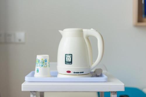a white blender on a table with a mug at 7 Days Hotel Panzhihua 54 Zhuanpan Center Branch in Panzhihua