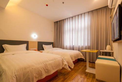 a hotel room with two beds and a window at 7 Days Hotel Panzhihua 54 Zhuanpan Center Branch in Panzhihua