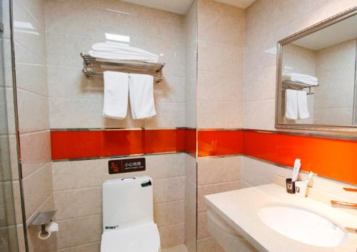 La salle de bains est pourvue d'un lavabo, de toilettes et d'un miroir. dans l'établissement 7Days Inn Shenyang Railway Station Taiyuan Street Branch, à Shenyang