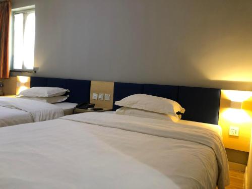 a hotel room with two beds and a window at 7Days Inn Laiwu New Bus Station Branch in Laiwu