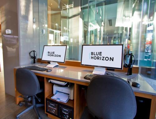 two computer monitors sitting on top of a desk at Blue Horizon Hotel in Vancouver