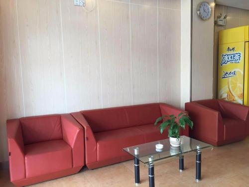 a red couch and a table in a room at 7Days Inn Nanning Jiangnan Bus Station Subway Exit Branch in Nanning