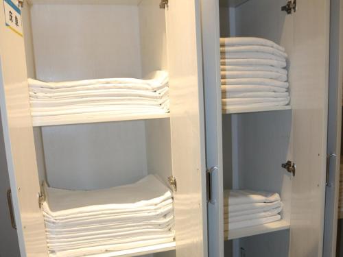 a closet with white folded towels on shelves at 7Days Inn Xianyang Xingping Jincheng Road Branch in Xianyang