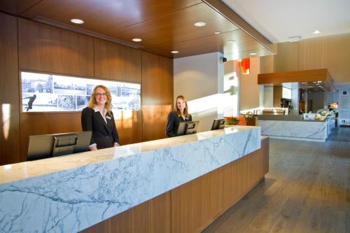 two women standing at a counter in a lobby at Blue Horizon Hotel in Vancouver
