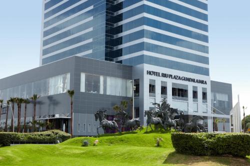 un edificio con una estatua de caballos delante de él en Riu Plaza Guadalajara, en Guadalajara