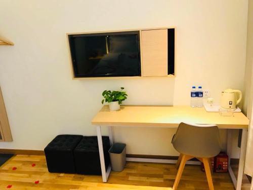 a desk in a room with a window and a chair at 7Days Inn Wuan Bus Station Branch in Handan