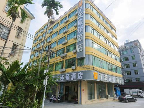 a tall yellow building with a sign on it at 7Days Inn Sanya Yalong Bay Branch in Sanya