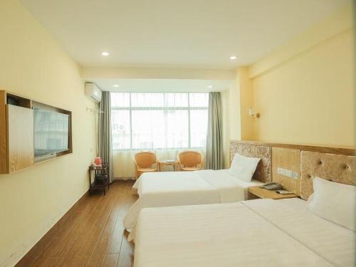 a hotel room with two beds and a window at 7Days Inn Sanya Yalong Bay Branch in Sanya