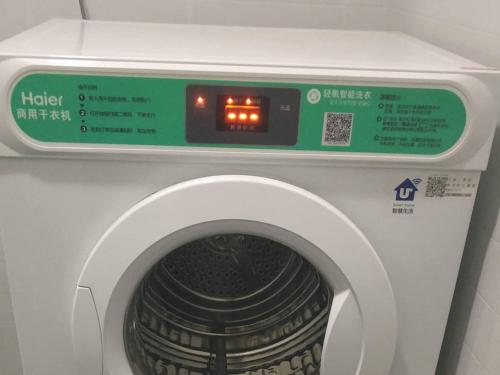 a washing machine with a clock on top of it at 7Days Inn Taiyuan South Railway Station Branch in Taiyuan