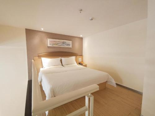 a bedroom with a large white bed in a room at 7Days Inn Guiyang Wenchang Pavilion in Guiyang