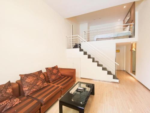 a living room with a couch and a staircase at 7Days Inn Guiyang Wenchang Pavilion in Guiyang