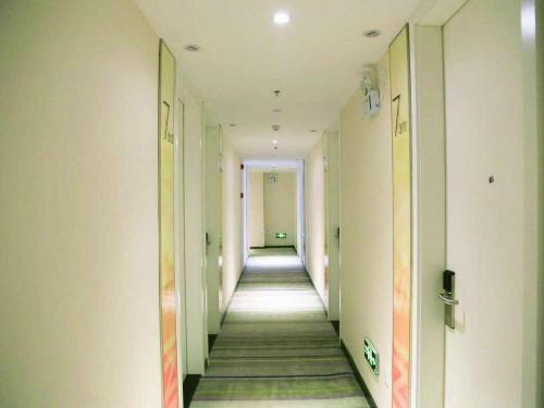 a hallway of an office building with a long corridor at 7Days Inn Ji'nan Changqing University Ginza Commercial Street Branch in Jinan