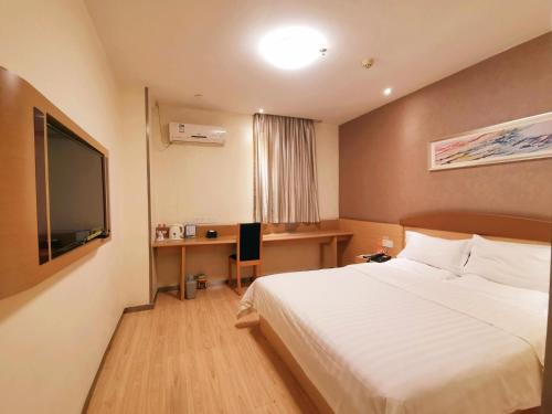 a hotel room with a bed and a flat screen tv at 7Days Inn Guiyang Xintian Avenue in Guiyang