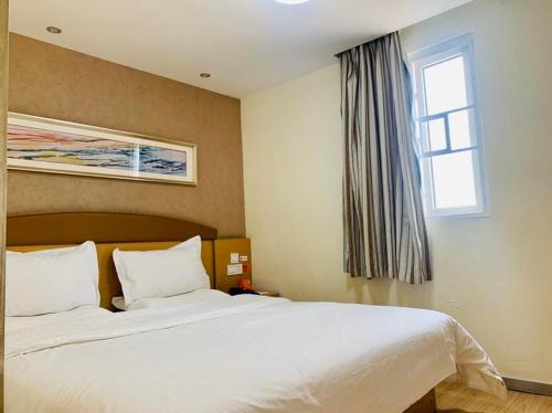 南寧市にある7Days Inn Nanning Qixing Roadの大きな白いベッドと窓のある寝室