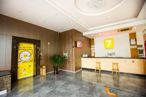eine Lobby mit gelber Tür und zwei Barhockern in der Unterkunft 7 Days Inn Haikou East Train Station North and South Fruit Market Fengxiang Road Branch in Haikou