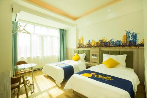 ein Hotelzimmer mit zwei Betten und einem Tisch in der Unterkunft 7 Days Inn Haikou East Train Station North and South Fruit Market Fengxiang Road Branch in Haikou