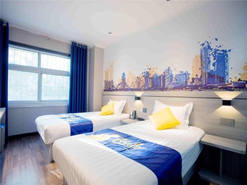 a hotel room with two beds and a painting on the wall at 7Days Inn Hengshui Hengbai International Branch in Hengshui