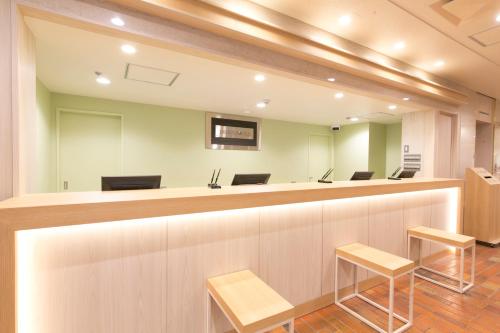a waiting room with chairs and a reception counter at Hotel S-Plus Hiroshima Peace Park in Hiroshima