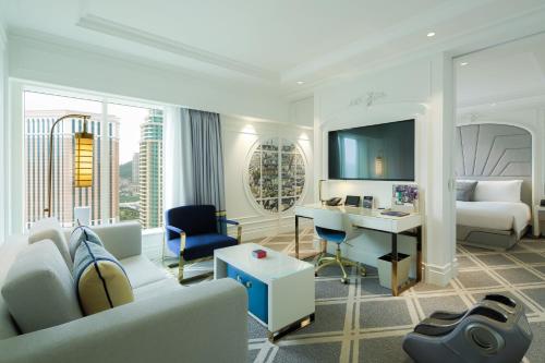 a living room with a couch and a desk in a hotel room at The Parisian Macao in Macau