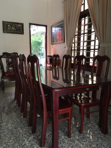 a dining room with a wooden table and chairs at Maily Hostel in Hue