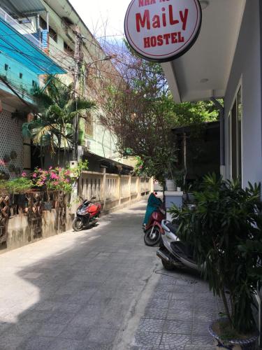 a row of scooters parked outside of a shop at Maily Hostel in Hue