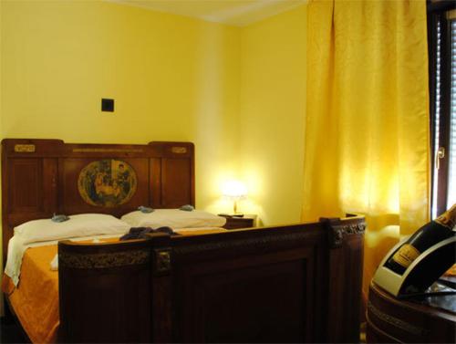 a bedroom with a bed with a wooden head board at Hotel Cigno Reale in Rolo